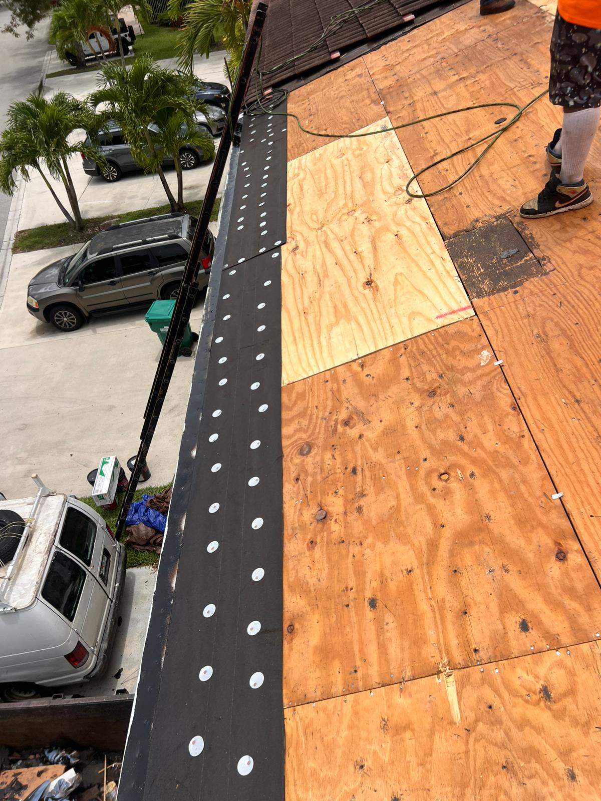 Emergency roofing services crew securing a tarp over storm damage on a Miami home