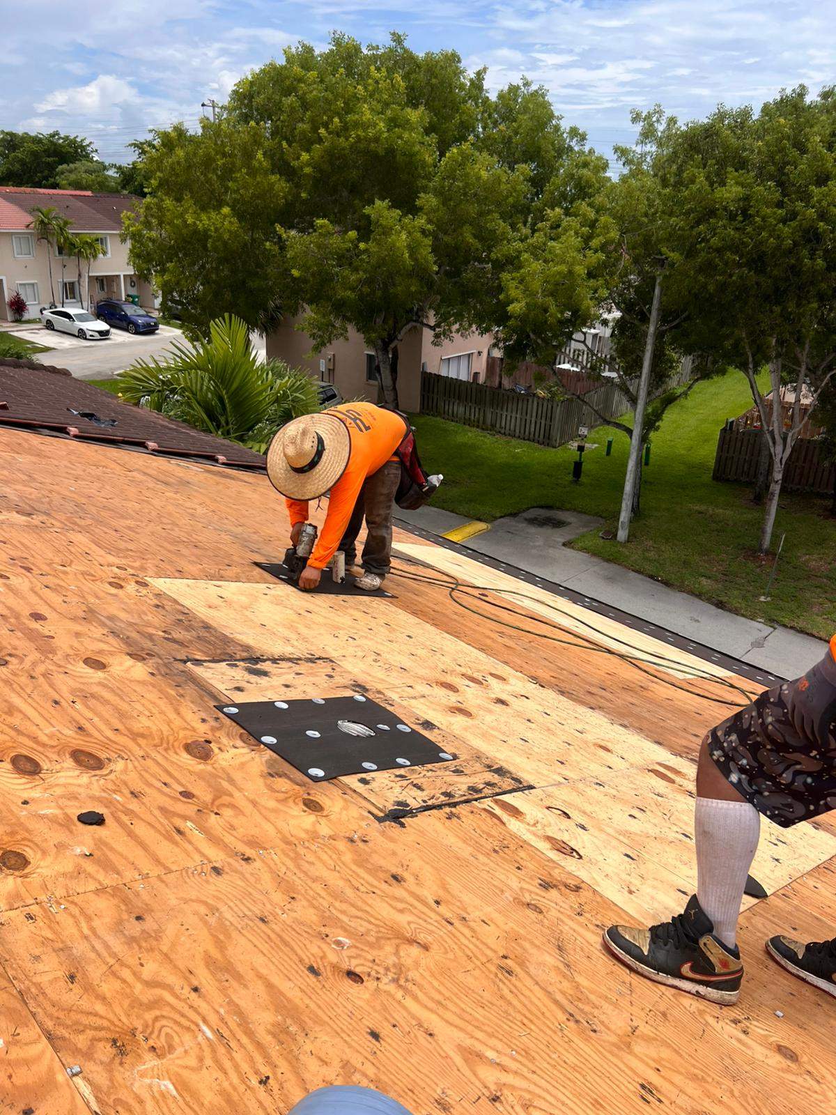 Barrel tile roof in Miami being examined during a roof inspection and maintenance visit